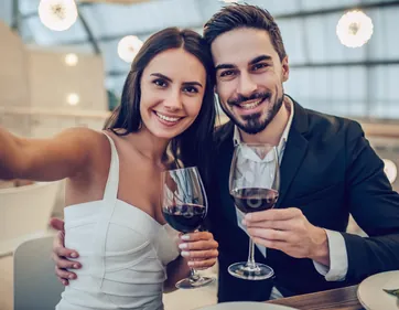 A couple holding glasses of wine at a restaurant