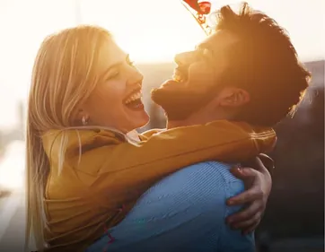 A couple embracing outdoors in warm sunlight